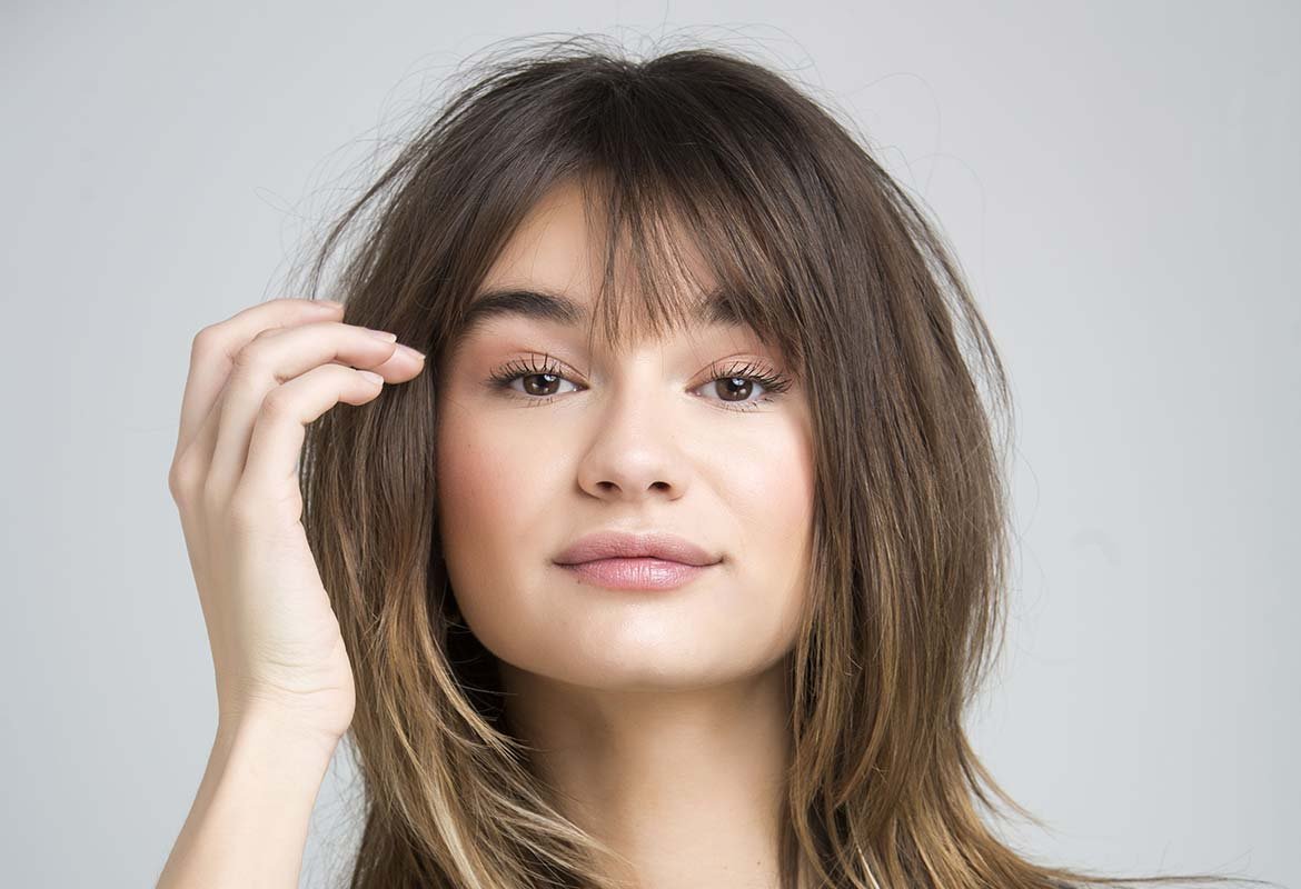 Otro truco para saber cómo dar volumen al pelo fino es combinar un corte a capas con un flequillo desfilado bien fijado con la Laca Elnett de L’Oréal Paris.